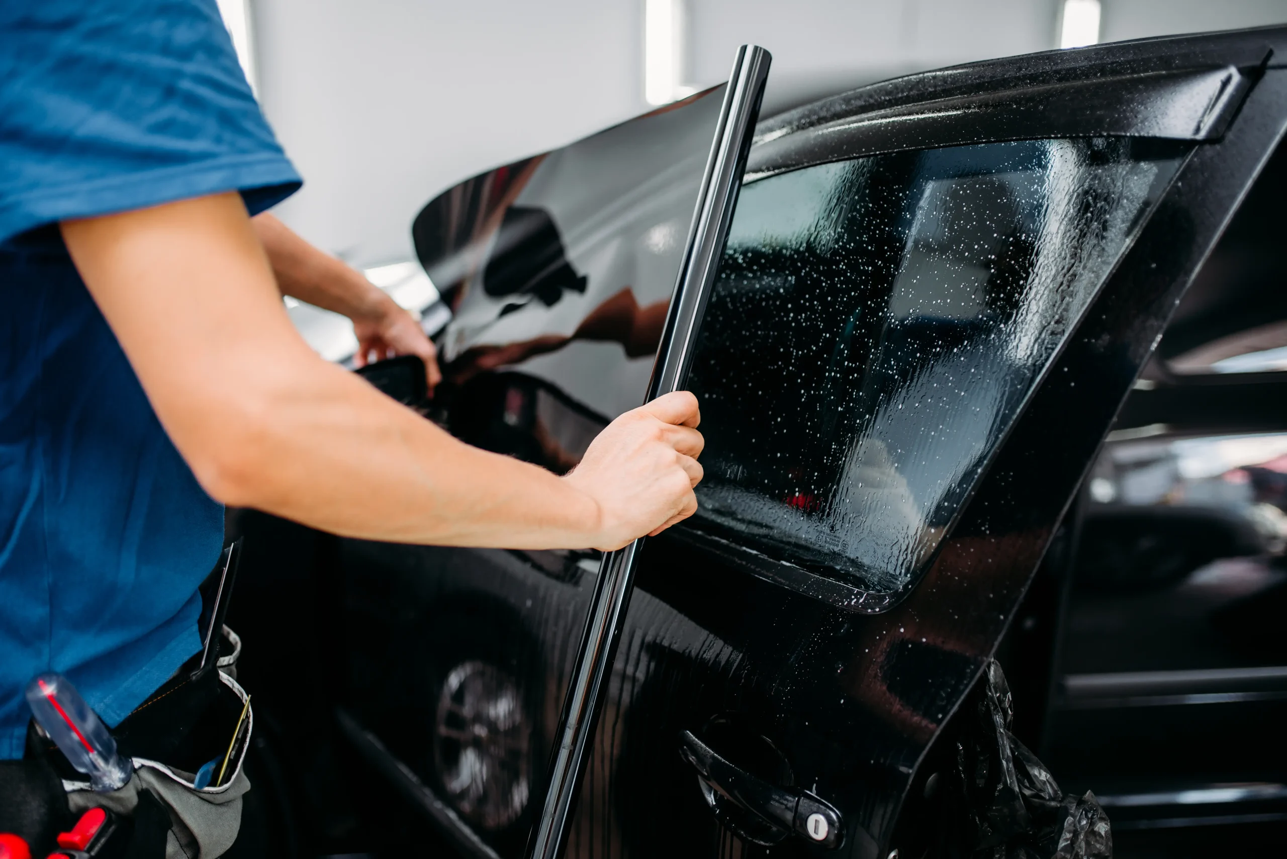 male specialist applying car tinting film installation process tinted auto glass installing procedure copy