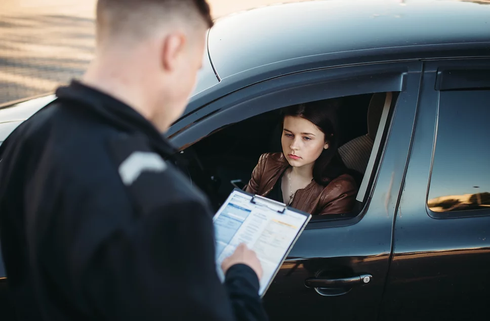 policeman uniform writes fine female driver